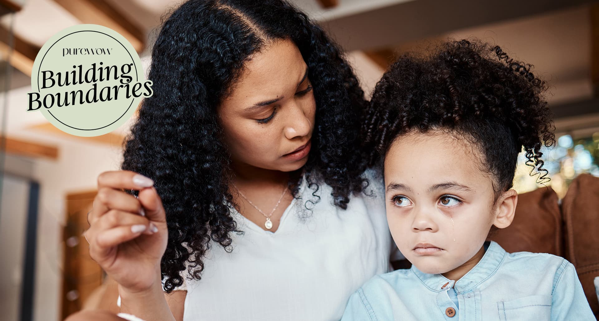 A mother gently talks to her very upset daughter