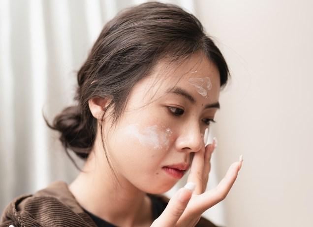 Why Does My Sunscreen Pill? And How To Prevent It Universal: a woman applying sunscreen to her face